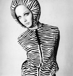 a woman in a zebra print dress and hoodie with her hands on her hips