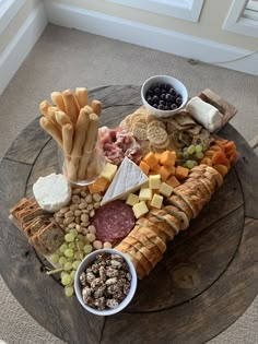 an assortment of cheeses, crackers, and meats on a wooden table