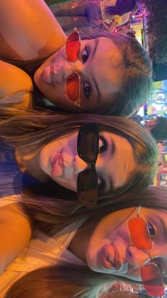 three beautiful young women laying next to each other in front of a neon light display