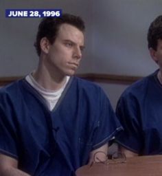 two men in blue scrubs sitting at a table