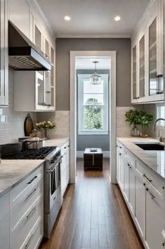 a long narrow kitchen with white cabinets and wood flooring, along with stainless steel appliances