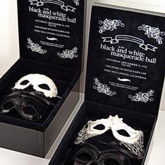 two black and white masquerade masks in a box