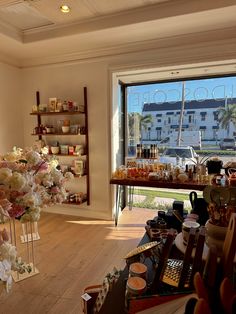 a room filled with lots of different types of items and flowers in vases next to a window