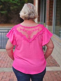 Experience effortless elegance in our V-Neck Ruffle Sleeved Top in Fuchsia! Featuring a delicate v-neckline with lace trim and charming short ruffled sleeves, this top is sure to turn heads. The lace yoke on the back adds a touch of femininity and grace, making it a must-have addition to your wardrobe. Elevate your style with this stunning top! ABOUT THIS ITEM: Made in China. Fabric is: Shell - 100% Polyester. Contrast - 100% Polyester. Hand wash inside out. Hang or line dry. The Model is 5'9, a Feminine Tops With Lace Trim And Flutter Sleeves, Chic Pink Tops With Crochet Trim, Feminine V-neck Top With Lace Sleeves, Pink Summer Blouse With Lace Sleeves, Pink Feminine Tops With Lace Sleeves, Pink Feminine Top With Lace Sleeves, Feminine Pink Tops With Lace Sleeves, Feminine Pink Lace Top With Lace Sleeves, Pink Lace Top With Ruffles For Spring