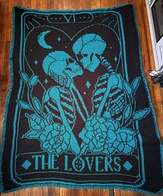 there is a knitted blanket that has two skeletons on it and the words, the lovers