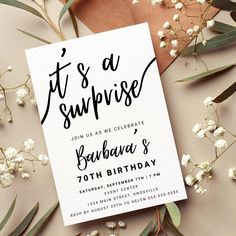 this is an image of a surprise birthday party card with flowers and eucalyptus leaves on it