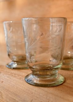 two glass cups sitting on top of a wooden table