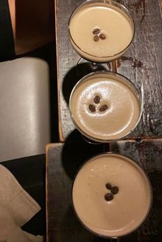 three glasses filled with liquid sitting on top of a table