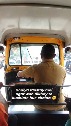 a man sitting in the driver's seat of a yellow truck with a message written on it