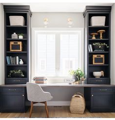 an office with black bookcases and white walls