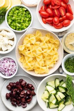 several bowls filled with different types of pasta and veggies next to each other