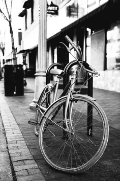 an old bicycle is chained to a bench