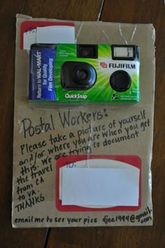 a camera sitting on top of a piece of paper next to an ad for fuji film