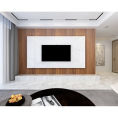 an empty living room with a flat screen tv mounted on the wall and white walls