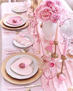 the table is set with pink and gold plates