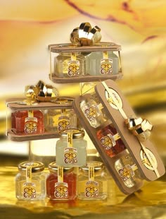 an assortment of honeys and jams in glass containers with gold bows on them