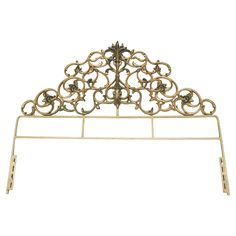 a gold metal headboard with ornate designs on it's sides and an intricate design at the top