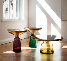 three glass tables sitting on top of a hard wood floor