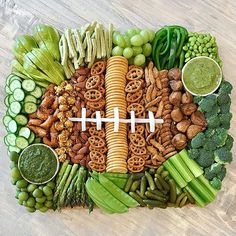 a football shaped platter filled with vegetables and snacks