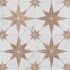 a white and brown tiled floor with star designs on the top, along with marble floors