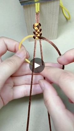 two hands are working on something with string