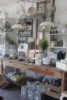 a room filled with lots of pots and pans on top of a wooden table