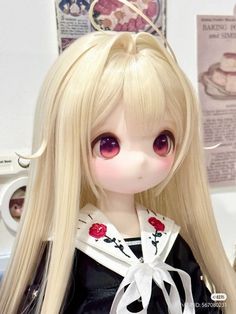 a doll with long blonde hair wearing a black dress