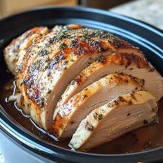 sliced pork in a slow cooker with herbs on the top and meat sauce on the side