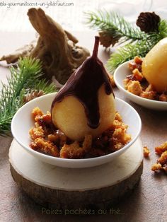 two small white bowls filled with dessert on top of a wooden table next to pine cones