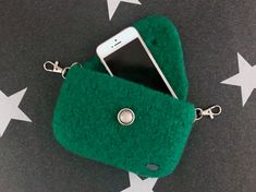 a cell phone is in a green purse