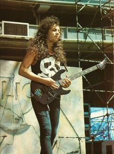 a man with long hair is playing an electric guitar at a music festival or concert