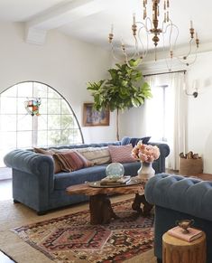 a living room filled with furniture and a chandelier hanging over the top of it