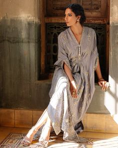 a woman sitting on the ground in front of a door