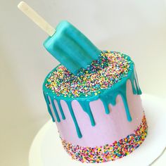 a birthday cake with sprinkles and an ice cream stick sticking out of it