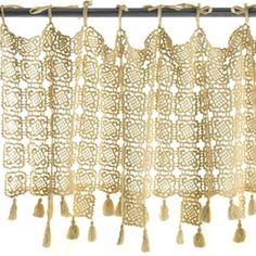 an old curtain with tassels hanging from it's side on a metal rod