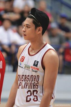 a basketball player standing in front of a crowd with his hand on his hip and looking to the side