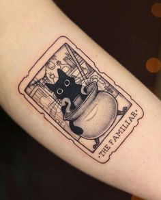 a black and white cat in a pot tattoo on the arm