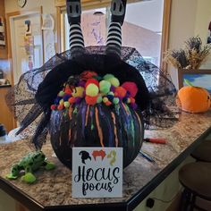 a decorated pumpkin sitting on top of a counter next to a sign that says hoccus pouss