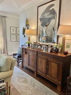 a living room filled with furniture and pictures on the wall