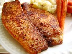 a white plate topped with fish, carrots and mashed potatoes