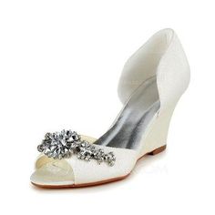 a pair of white high heeled shoes with a flower decoration on the toe and an ankle