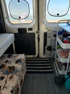 the inside of a small vehicle with two windows and storage shelves on each side of the door