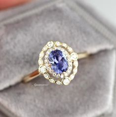 a close up of a ring with a blue stone in it on a velvet case