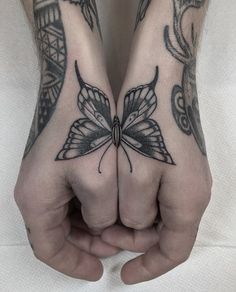 two hands with tattoos on them and one has a butterfly tattoo on the other hand