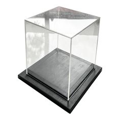 a glass box sitting on top of a black base