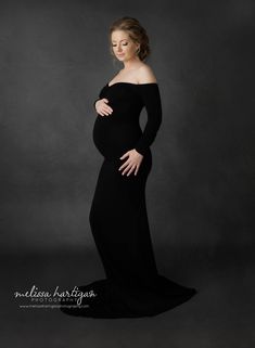 a pregnant woman poses in a black gown