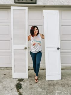 a woman standing in front of an open door with her hand on the side of the door