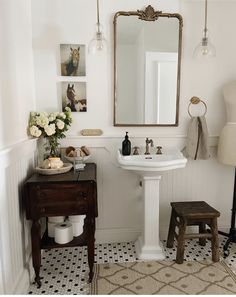 a bathroom with a pedestal sink, mirror and stools in it's corner