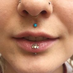 a close up view of a woman's nose with piercings