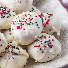 white chocolate covered cookies with sprinkles on a plate